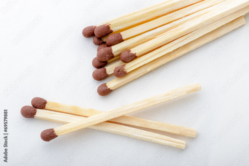 Close-up of matches on white paper background Close-up of matches on white paper background