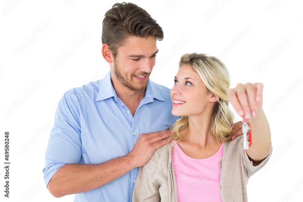 Attractive young couple showing new house key Attractive young couple showing new house key