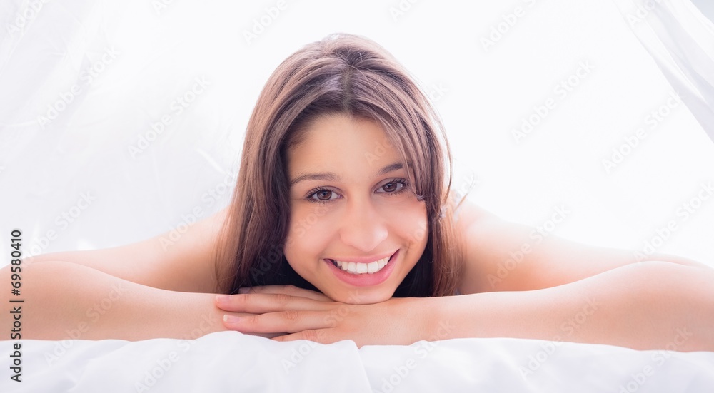 Beautiful brunette smiling at camera on bed Beautiful brunette smiling at camera on bed