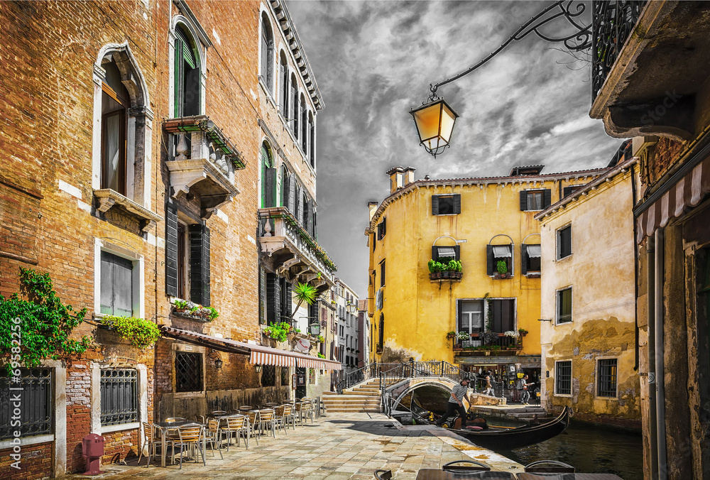 Fototapeta premium Narrow canal among old colorful brick houses in Venice
