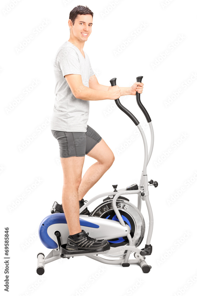 Young man exercising on a cross trainer machine Young man exercising on a cross trainer machine