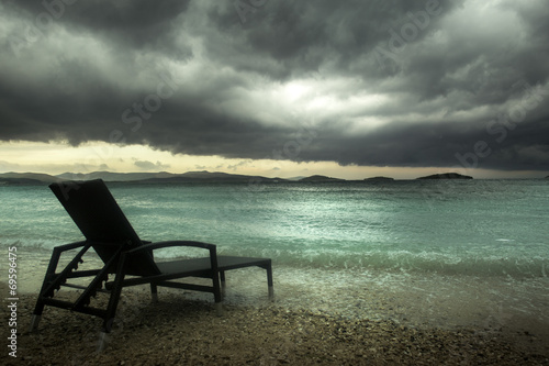 sun lounger on the turquoise sea under clouds