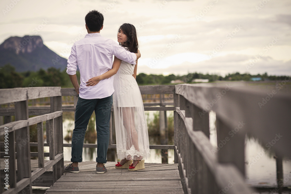 Beautiful married couple on the wooden bridge