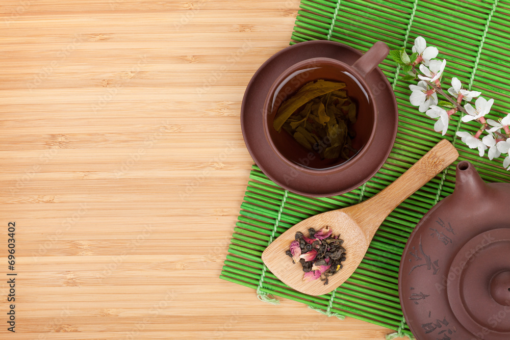Japanese green tea and sakura branch over mat Japanese green tea and sakura branch over mat