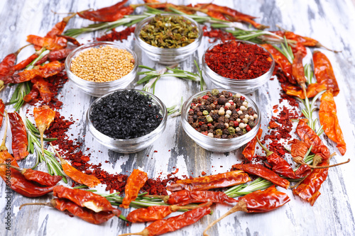 Spices with herbs and dried chilly pepper on wooden background © Africa Studio