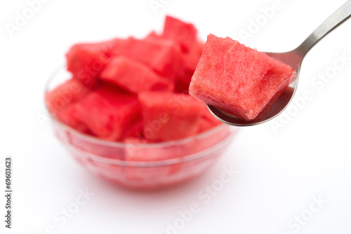 taking a piece of watermelon by spoon on white