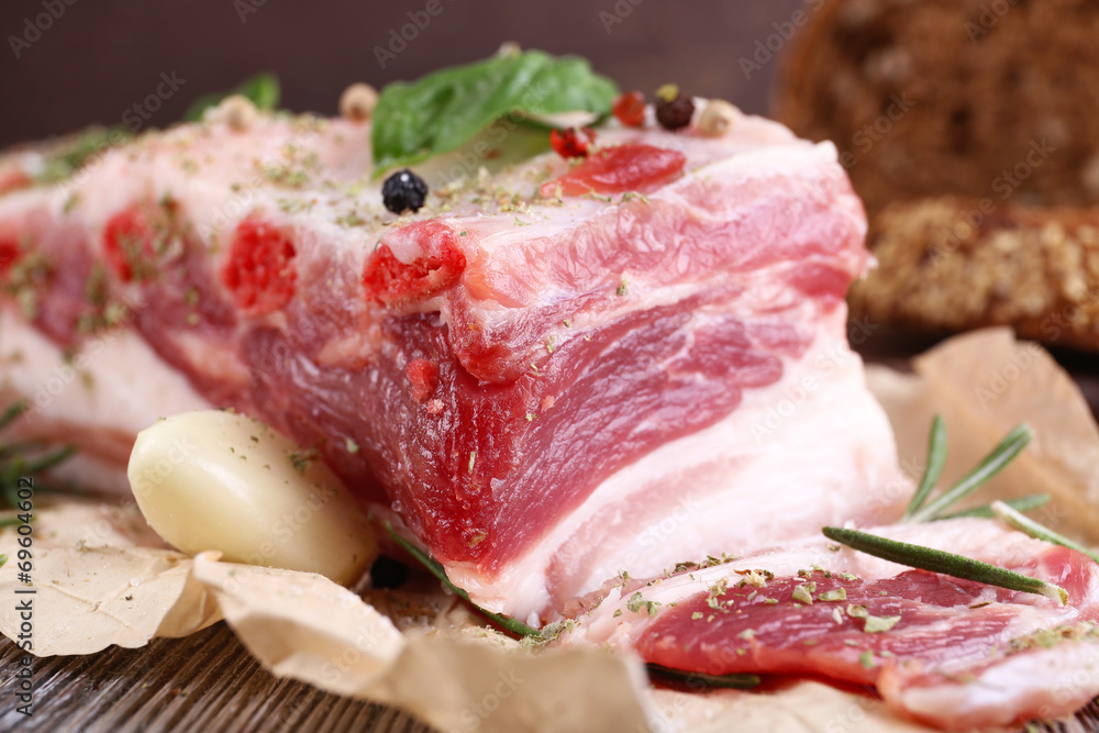 raw bacon with bread and spices on wooden table