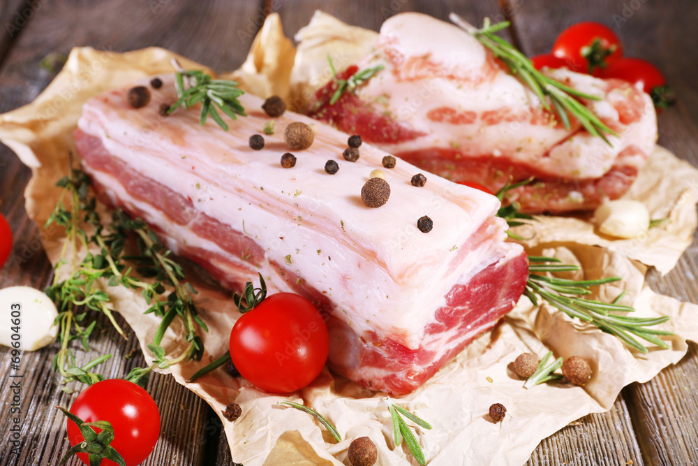 raw bacon with spices and tomatoes on wooden table