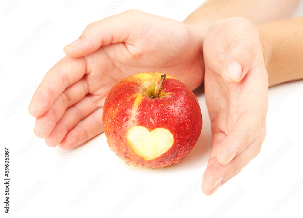 Red apple with heart in hands isolated on white