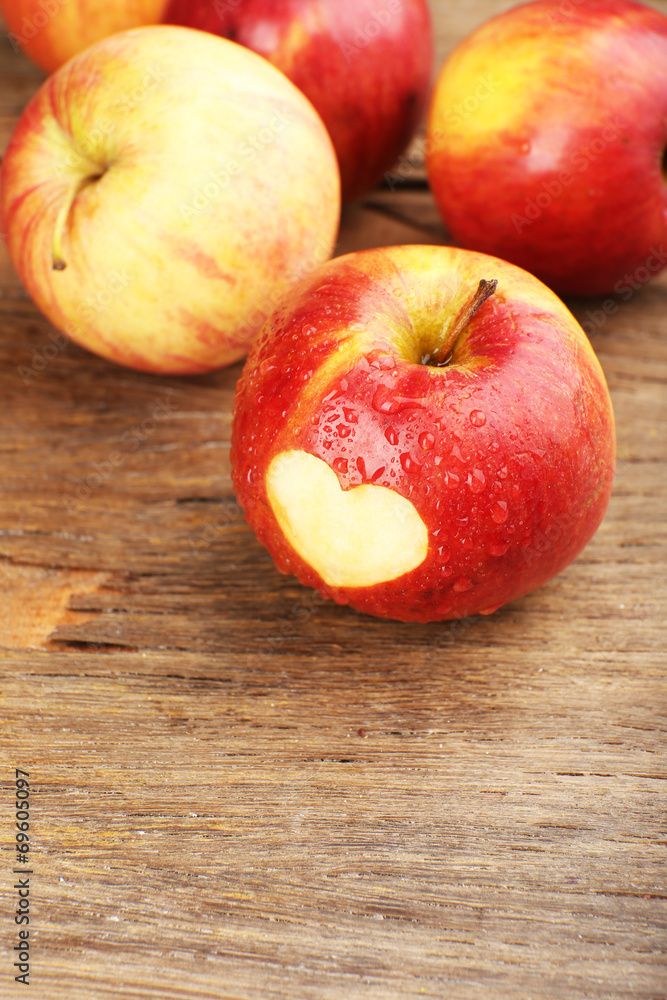 Red apple with heart on wooden table, close-up Red apple with heart on wooden table, close-up
