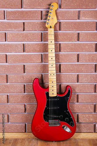 Guitar on brick wall background © Africa Studio