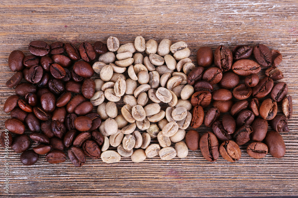 Naklejka premium Coffee beans on wooden background