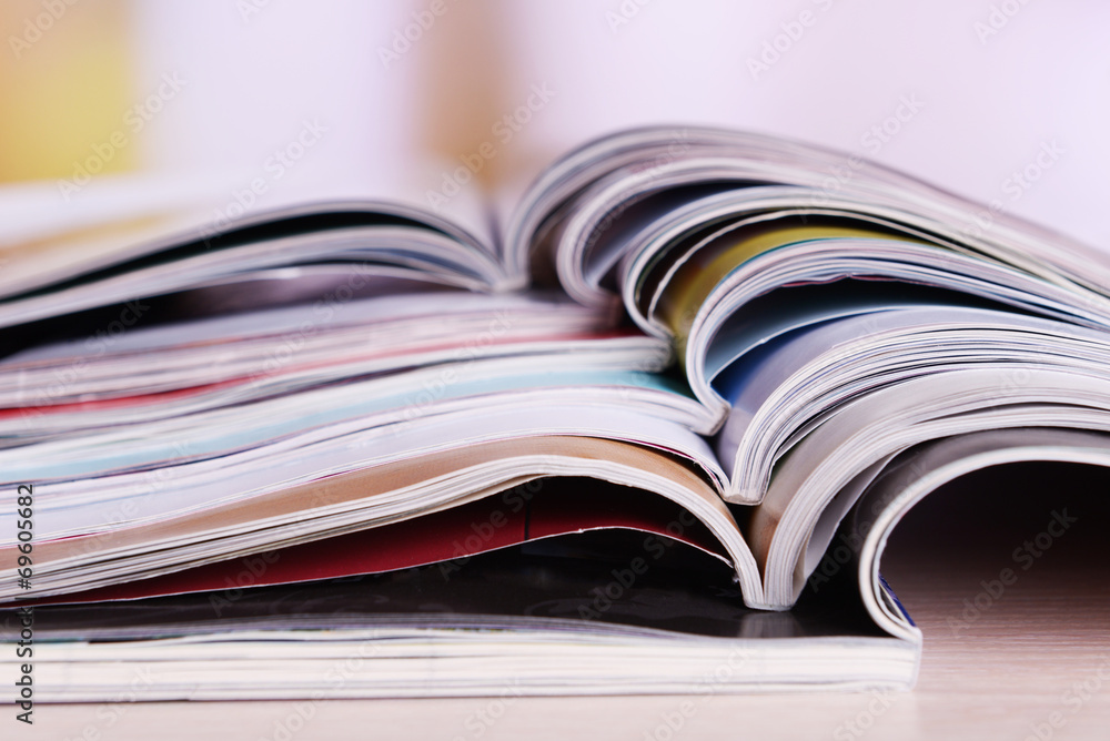 Magazines on wooden table on bright background Magazines on wooden table on bright background