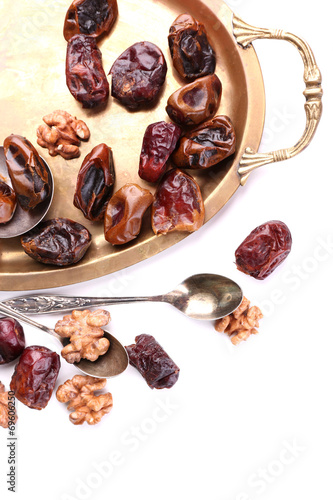 Tasty dates fruits on old metal tray, isolated on white © Africa Studio