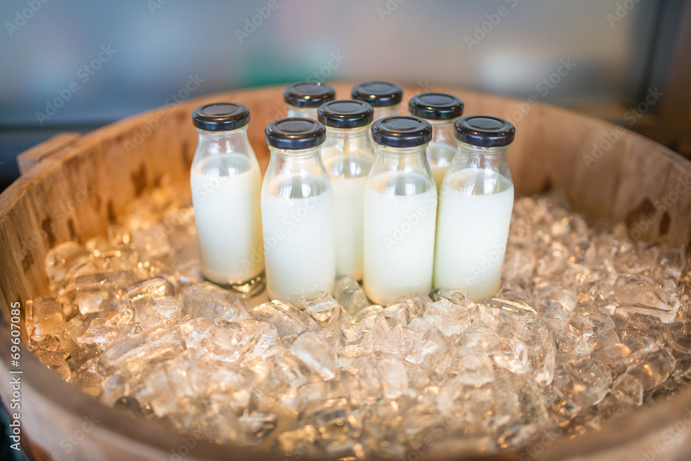 Closeup of bottles of milk set on ice wooden crate Closeup of bottles of milk set on ice wooden crate