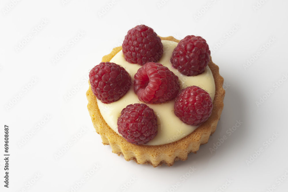 Tortelett mit Himbeeren auf weissem Untergrund Tortelett mit Himbeeren auf weissem Untergrund
