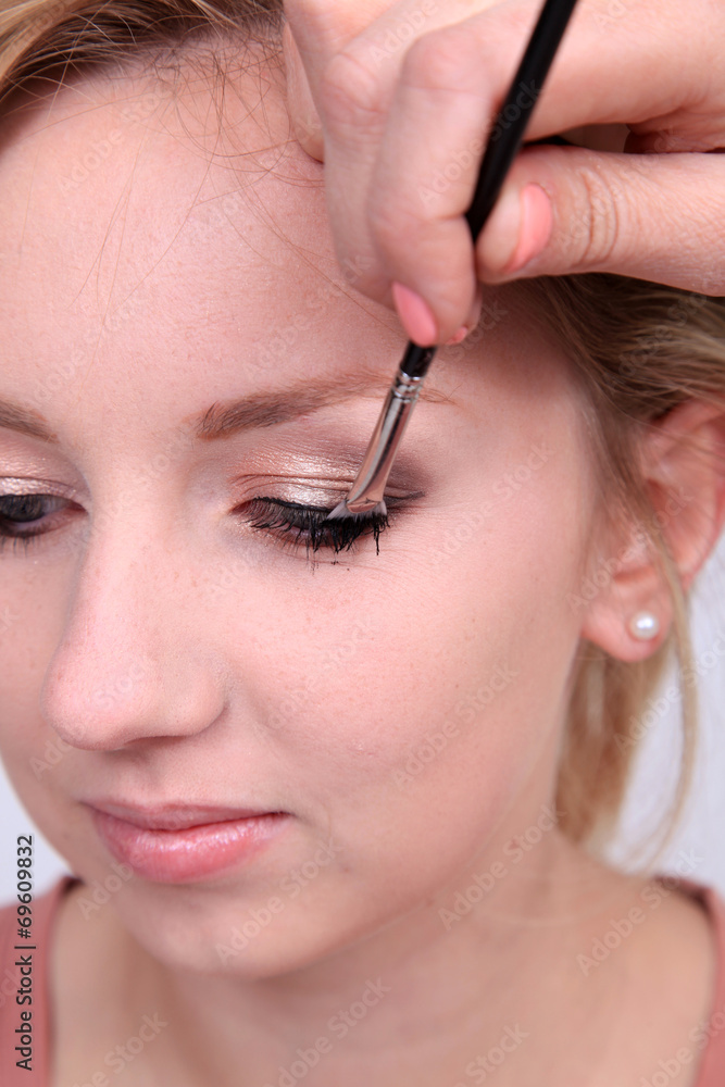 Makeup artist applying makeup to model