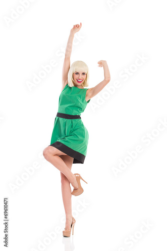 Cheering blonde girl in green dress
