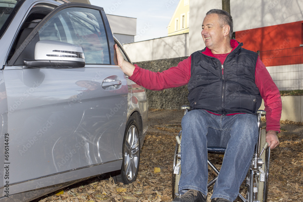 Man in a wheelchair in the fall next to their car Man in a wheelchair in the fall next to their car