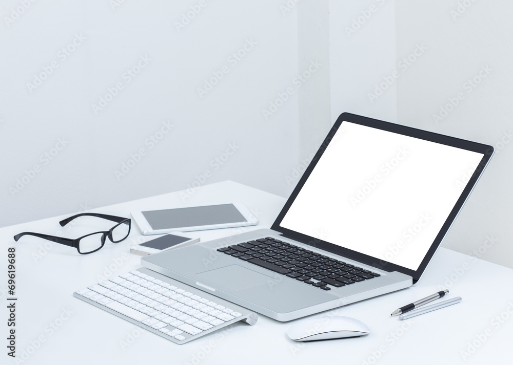 Blank screen laptop computer with accessories on white table Blank screen laptop computer with accessories on white table