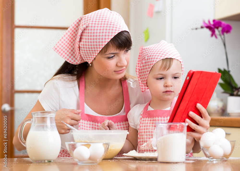 Mother and child preparing pastry together at kitchen and lookin Mother and child preparing pastry together at kitchen and lookin