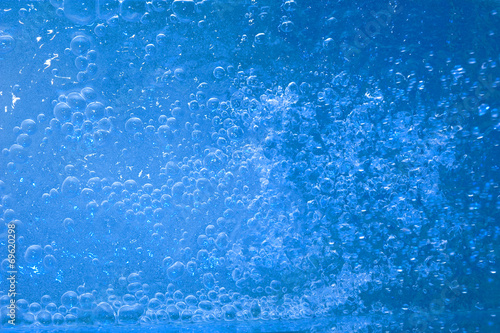 Blue drops of water on glass surface