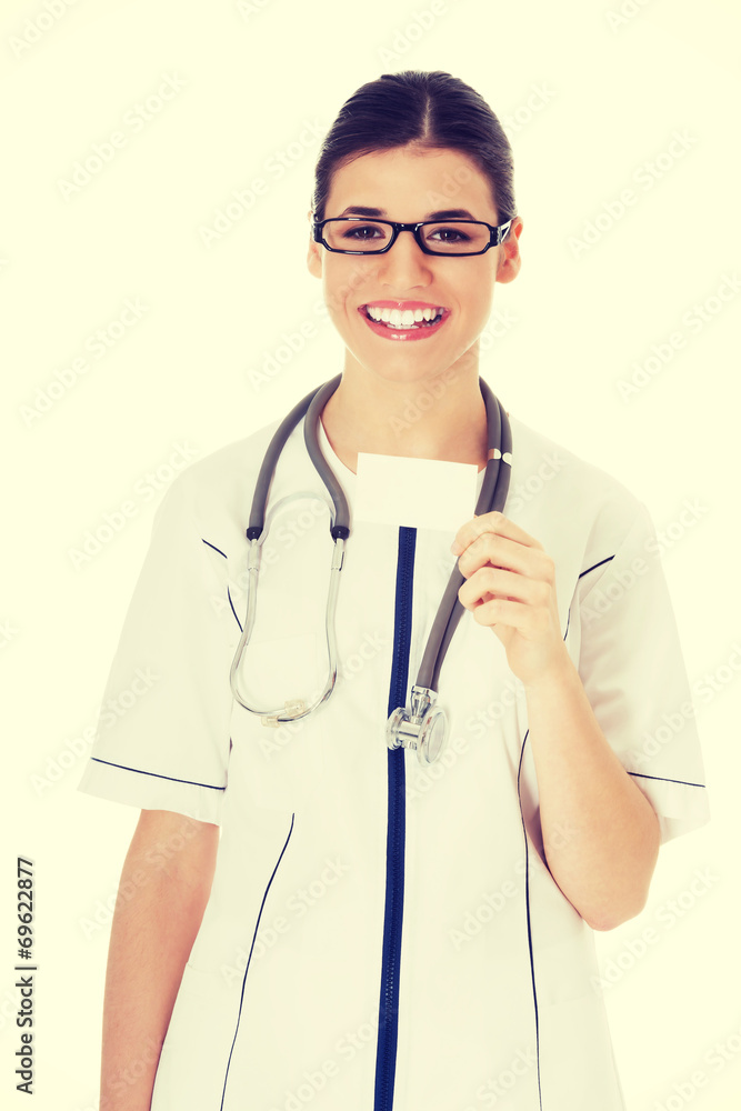 Young female doctor holding business card. Young female doctor holding business card.