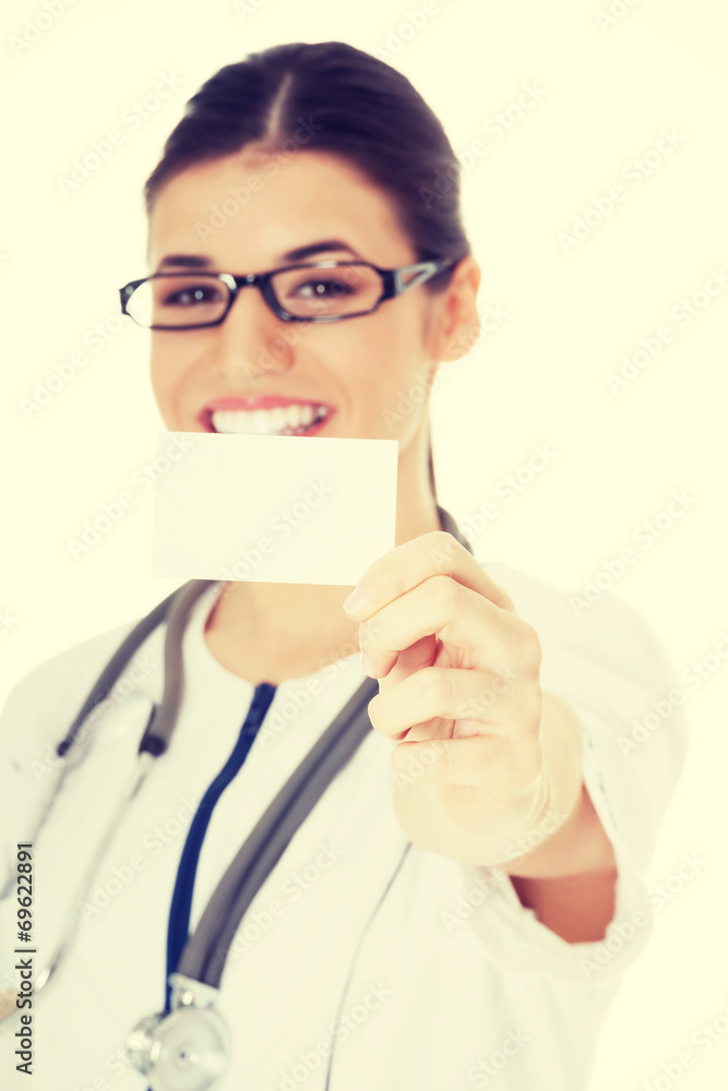 Young female doctor holding business card. Young female doctor holding business card.