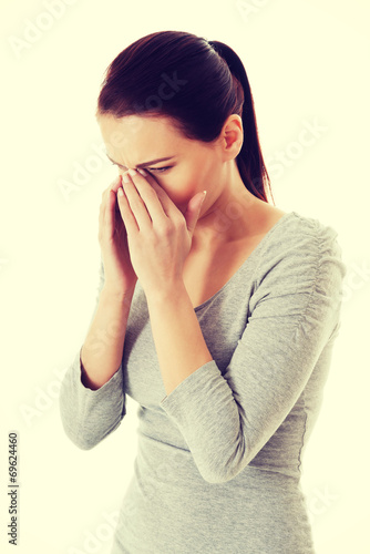 Young beautiful woman touching her nose.