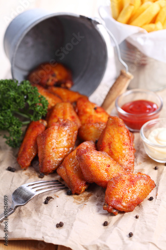 Obraz na płótnie chicken wings with sauce on brown paper w salonie