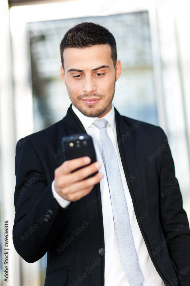Portrait of a young businessman texting on the phone Portrait of a young businessman texting on the phone
