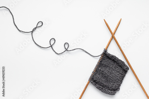 Piece of grey knitting on knitting needles