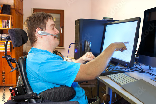 Man with infantile cerebral palsy using a computer. photo
