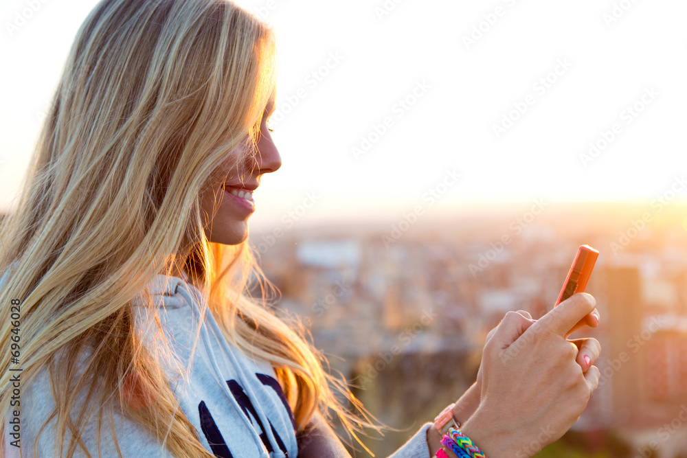 Beautiful blonde girl taking pictures of the city. - obrazy, fototapety, plakaty 