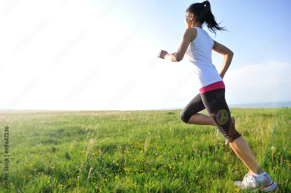 Runner athlete running on grass seaside Runner athlete running on grass seaside