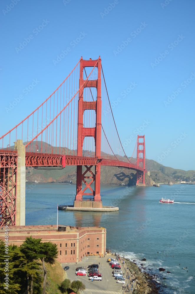 Golden Gate Bridge, a fort, surfers on a clear San Francisco day