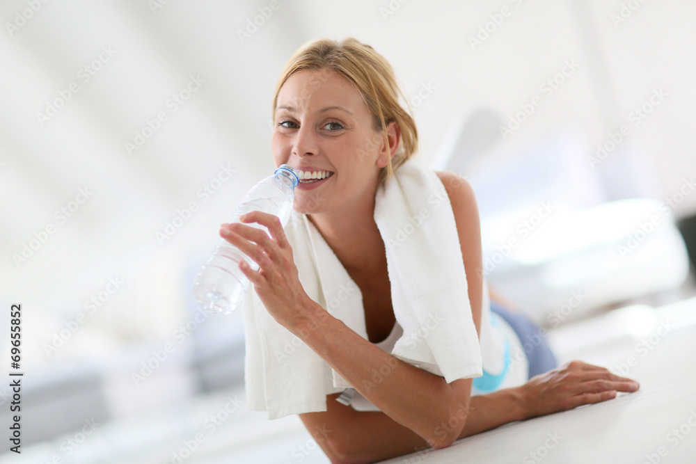 Closeup of fitness girl drinking water after exercising Closeup of fitness girl drinking water after exercising