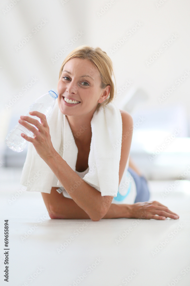 Closeup of fitness girl drinking water after exercising Closeup of fitness girl drinking water after exercising