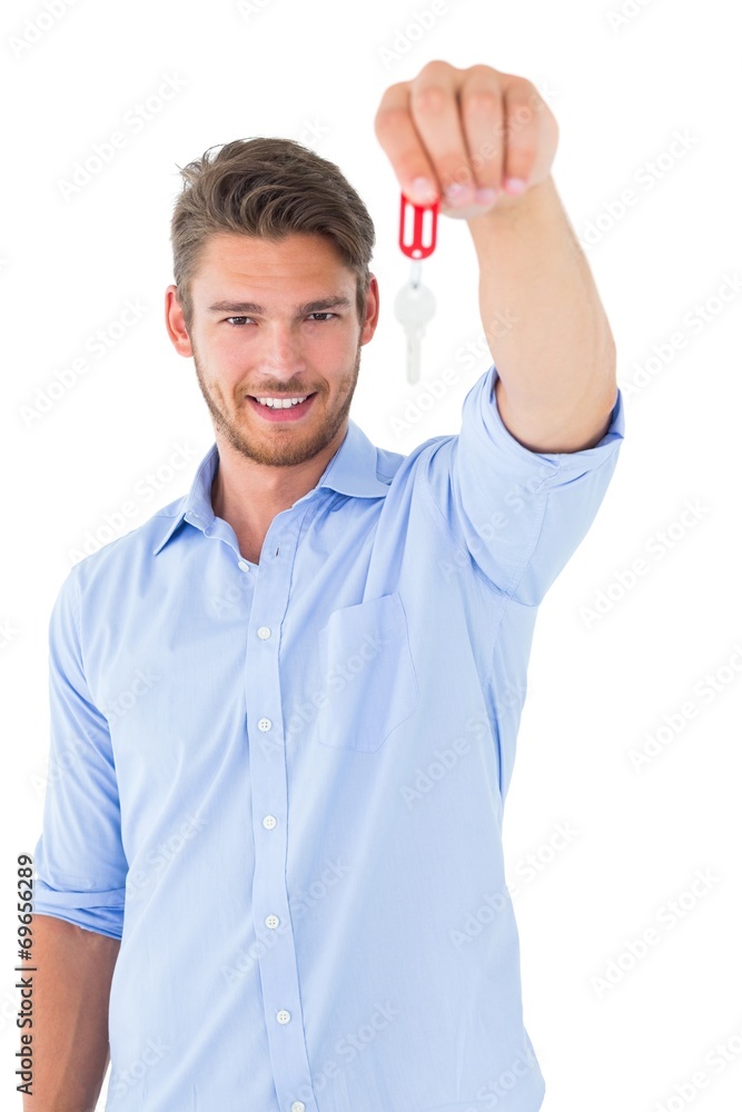 Handsome young man showing new house key Handsome young man showing new house key