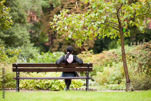 Girl sitting on a bench in a park