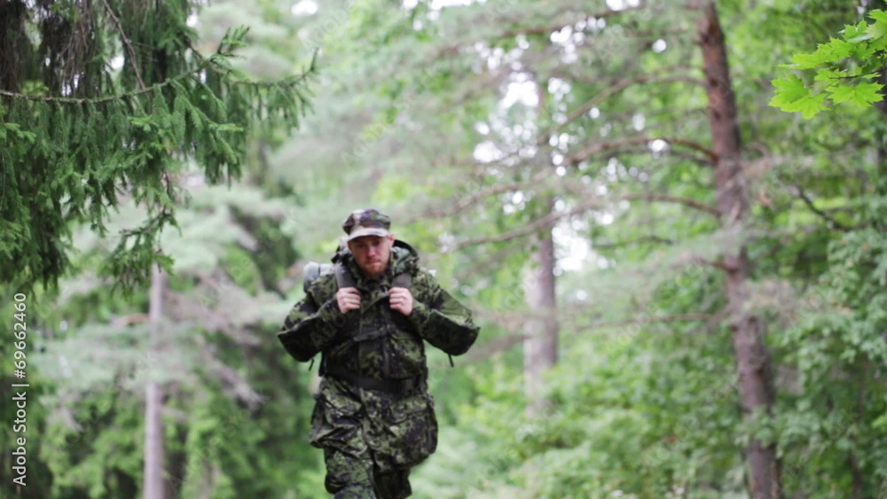 young soldier with backpack in forest