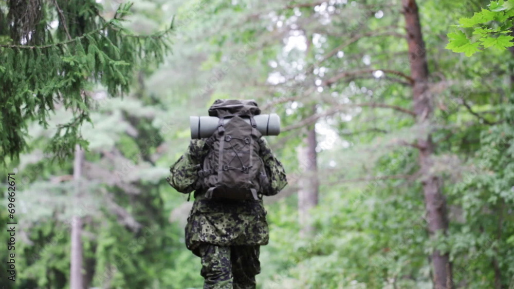 young soldier with backpack in forest young soldier with backpack in forest