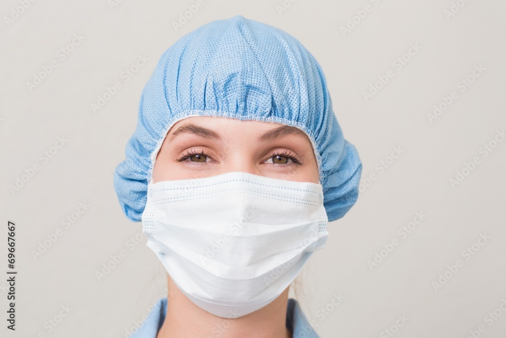 Dentist in surgical mask and cap looking at camera Dentist in surgical mask and cap looking at camera