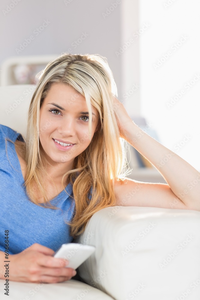 Beautiful woman text messaging in living room Beautiful woman text messaging in living room