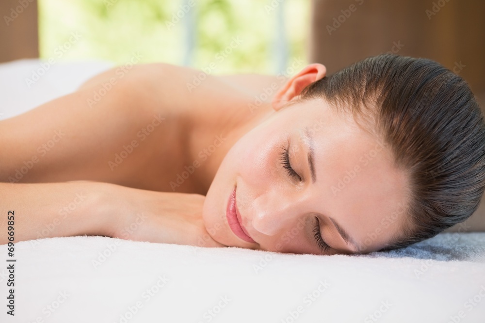 Beautiful woman lying on massage table at spa center Beautiful woman lying on massage table at spa center