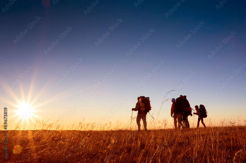 Hikers is walking on plateau in Crimea mountains during sunset Hikers is walking on plateau in Crimea mountains during sunset