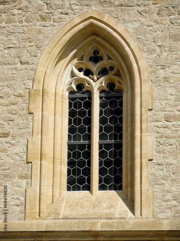 Ornamental gothic window in stone wall