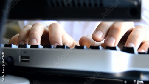 Man Types on Keybaord and Checks with a Pen