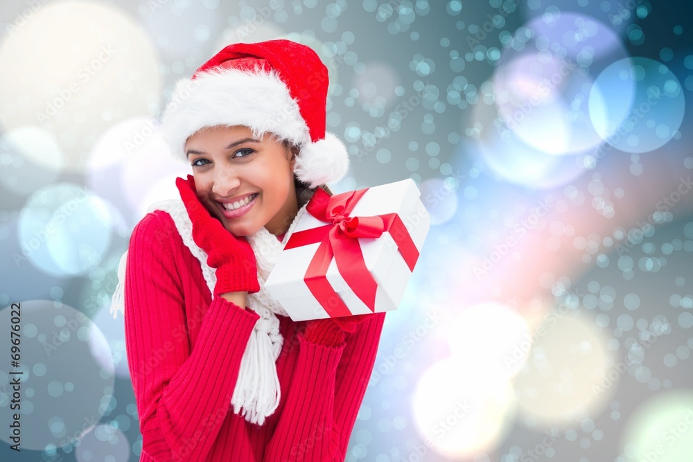 Composite image of festive brunette holding gift Composite image of festive brunette holding gift