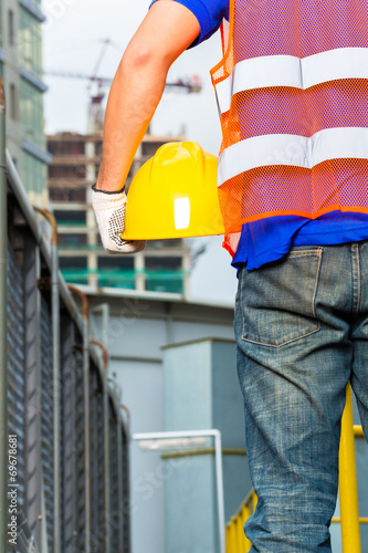 Worker on construction site with helmet or hard hat photo